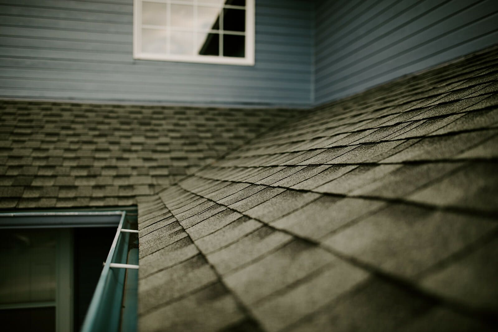 A close up of a roof with a window in the background