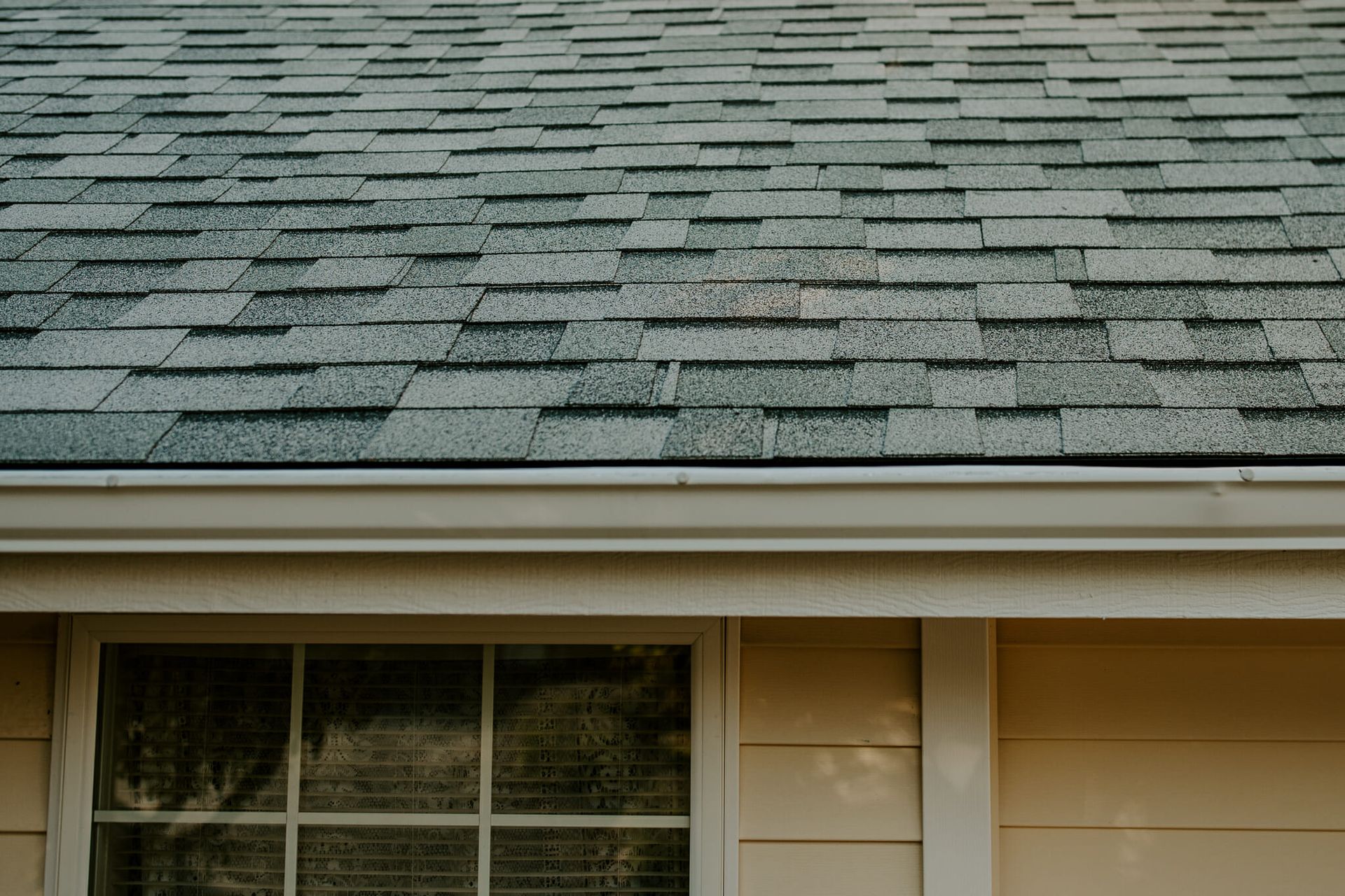 A close up of a house with a roof and a window.