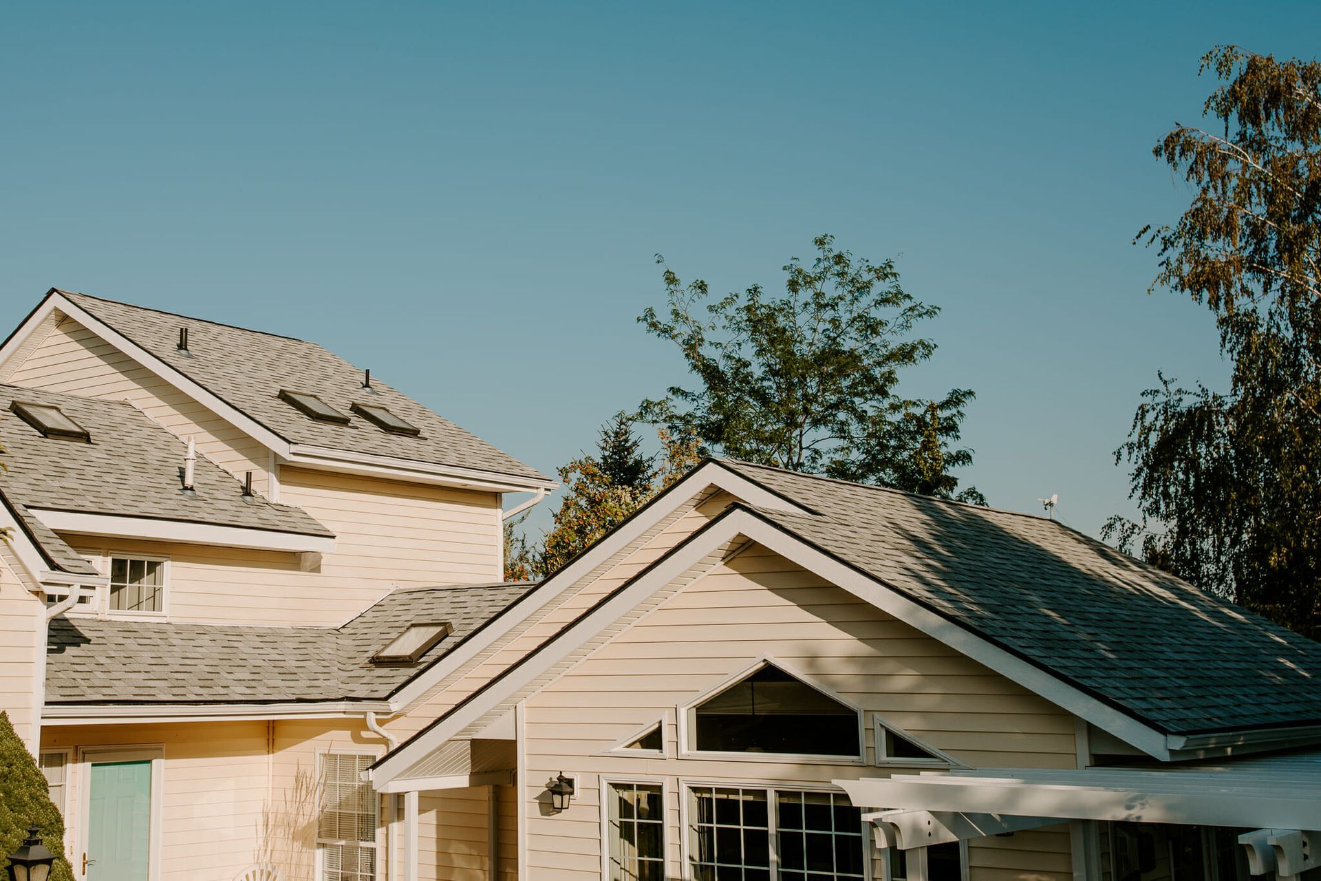 A white house with a gray roof and a blue sky in the background.