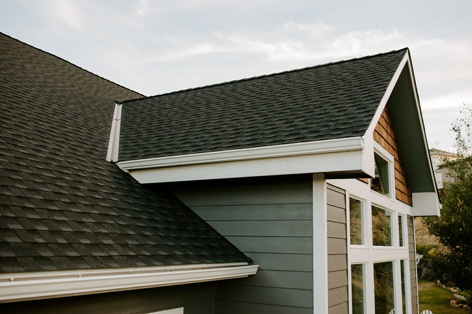 A house with a black roof and a white trim.