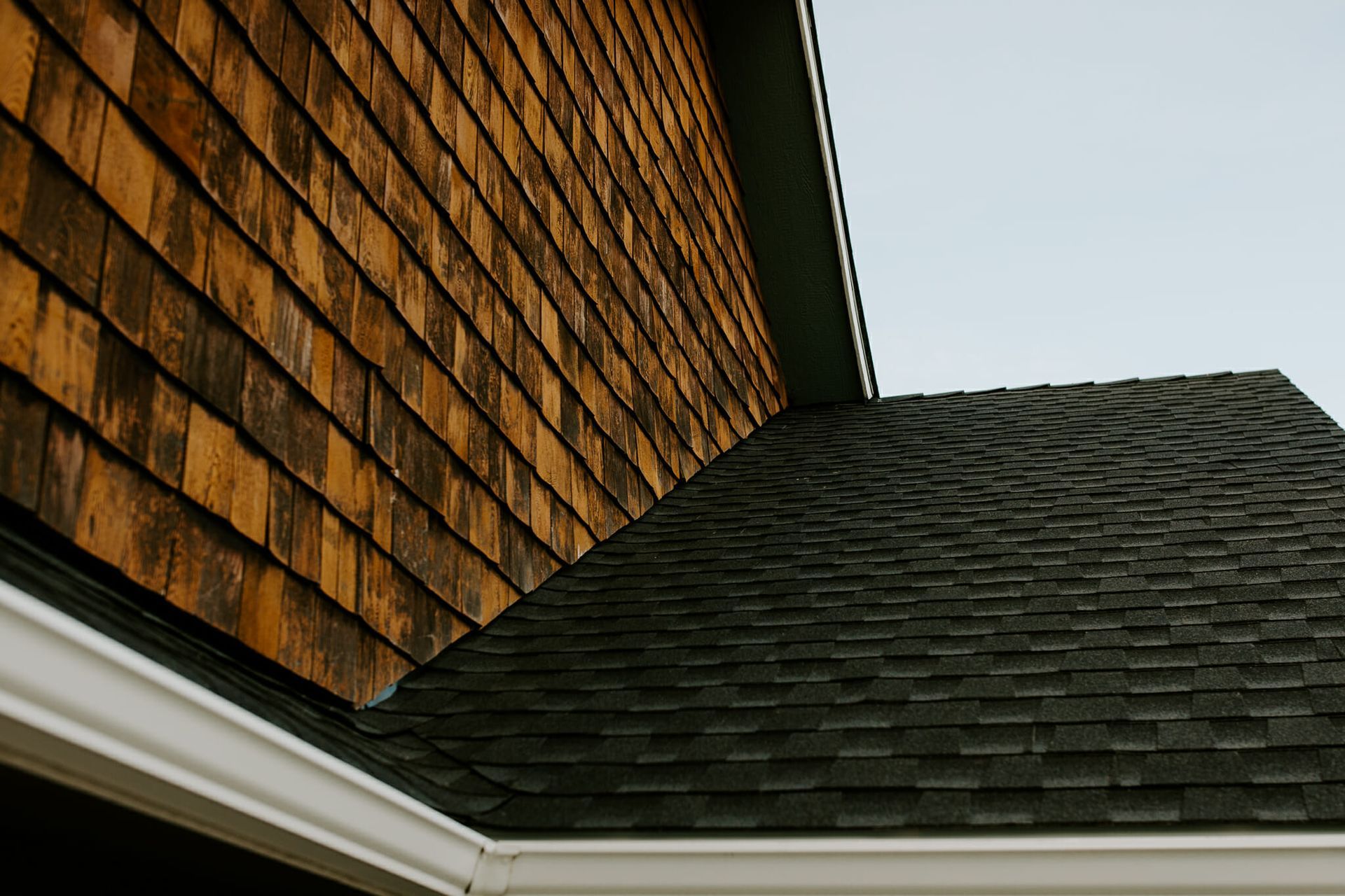 A house with a wooden siding and a black roof.