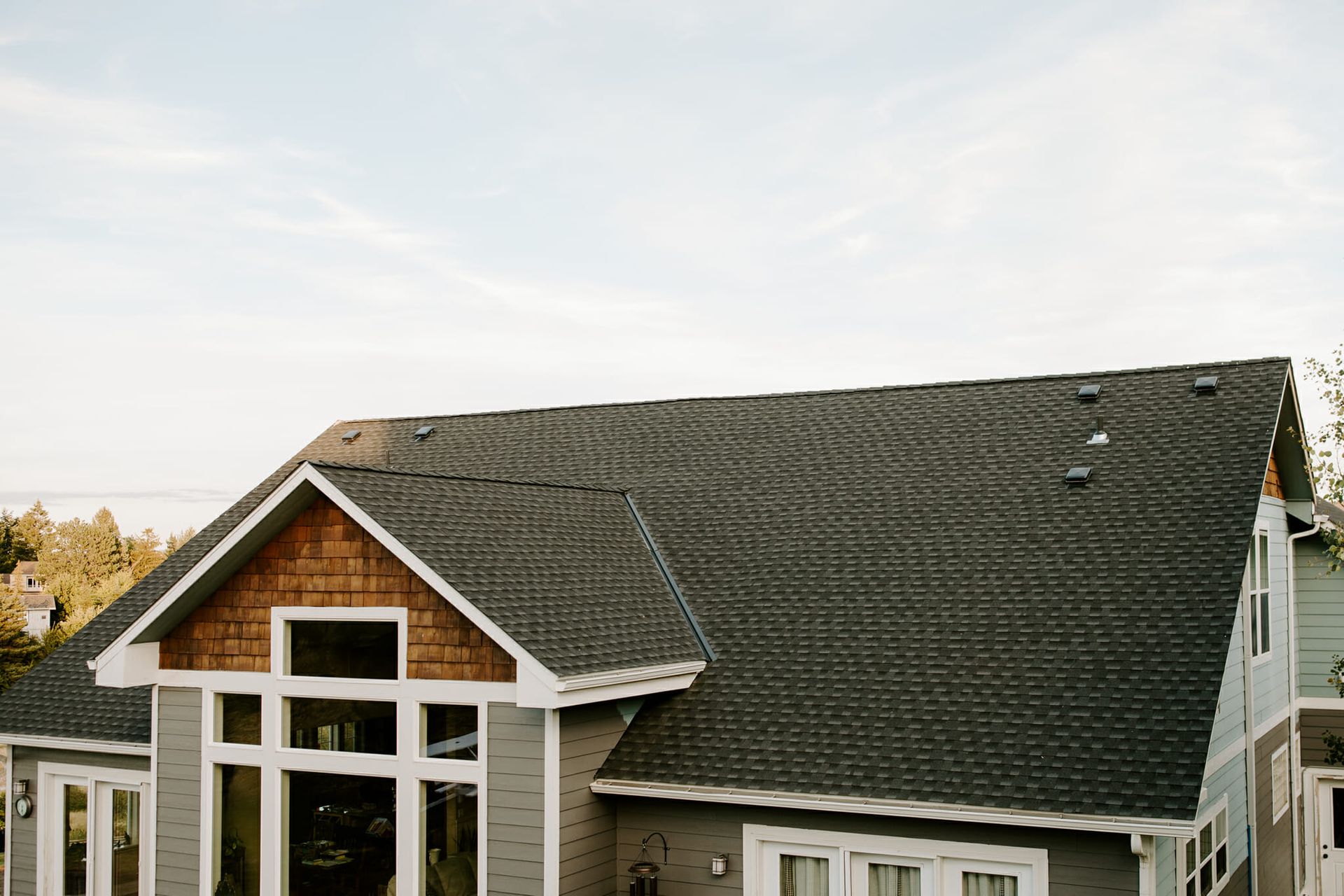 A large house with a black roof and a lot of windows.