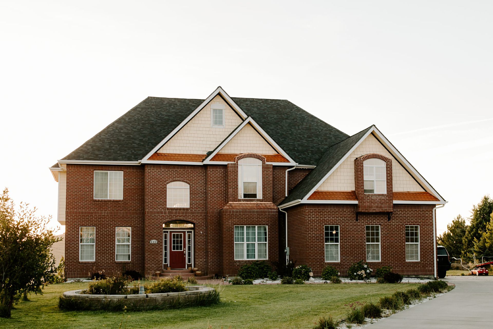 A large brick house with a driveway in front of it.