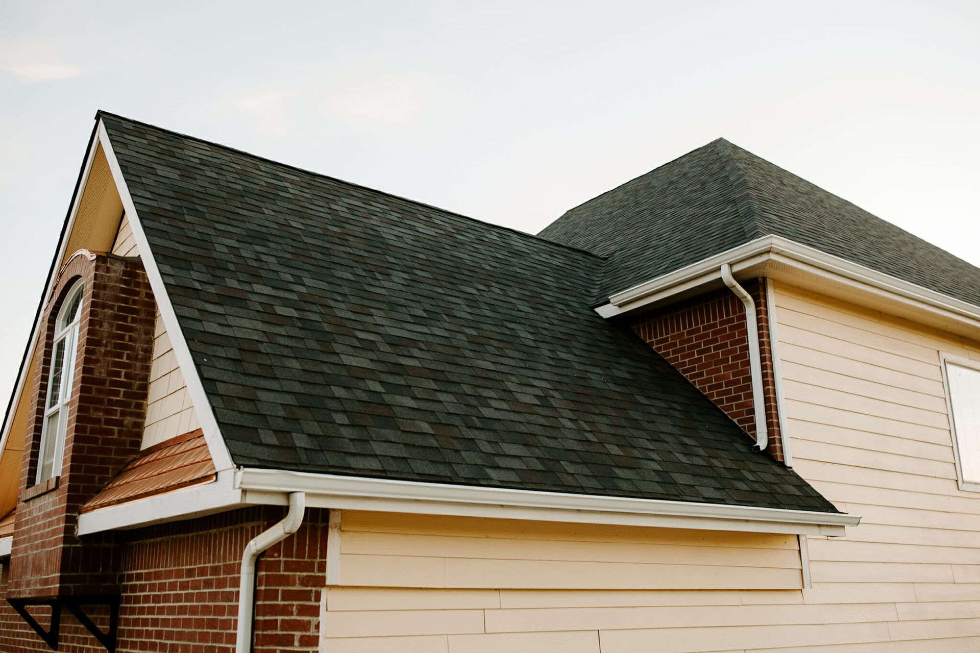 A house with a green roof and a brick chimney.