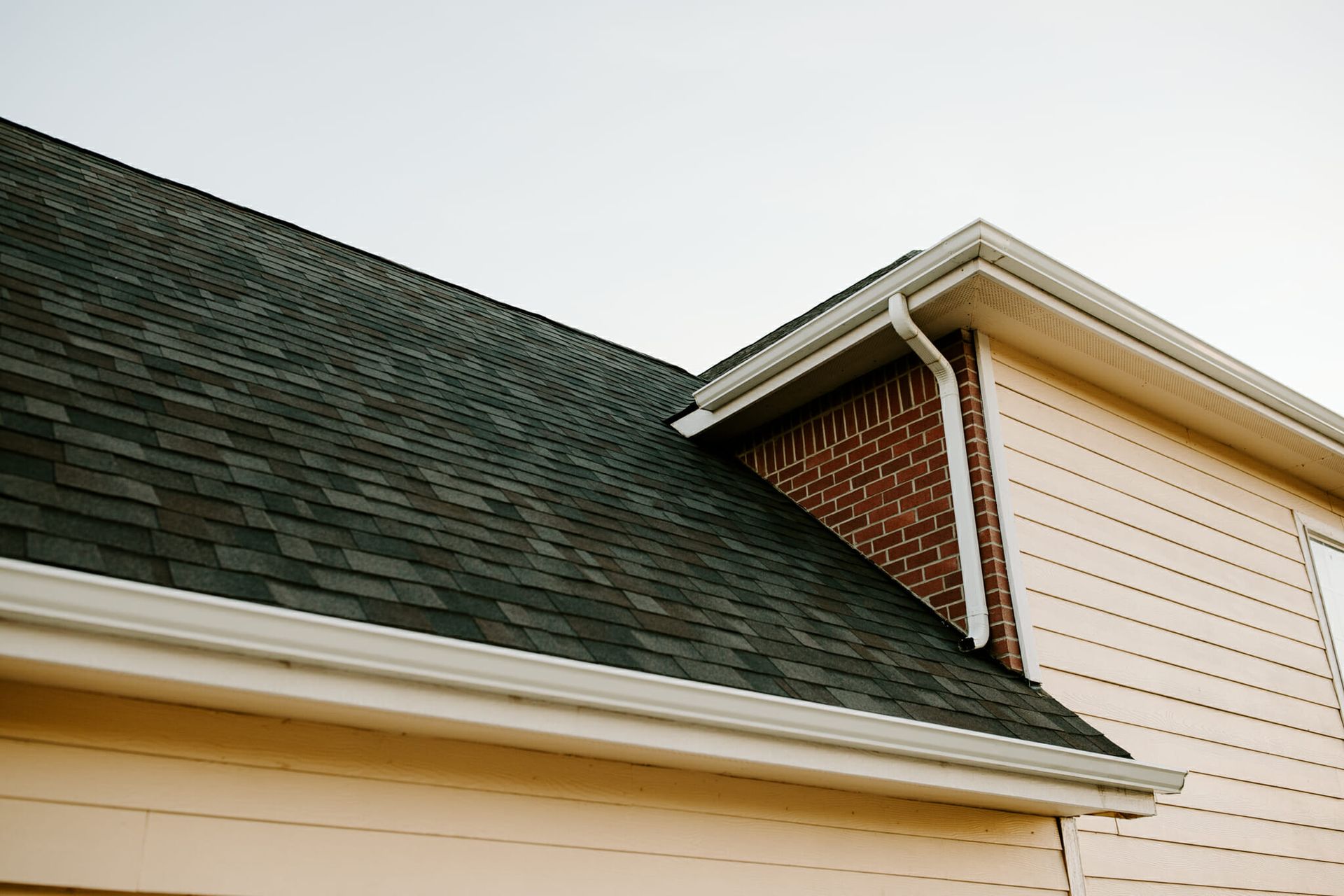 A close up of the roof of a house with a chimney.