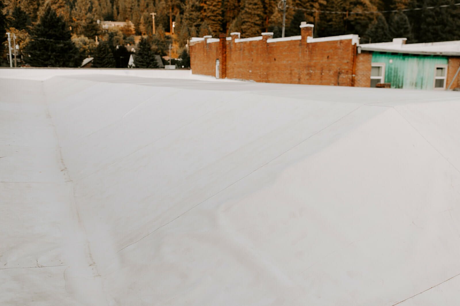 There is a lot of snow on the roof of a building.