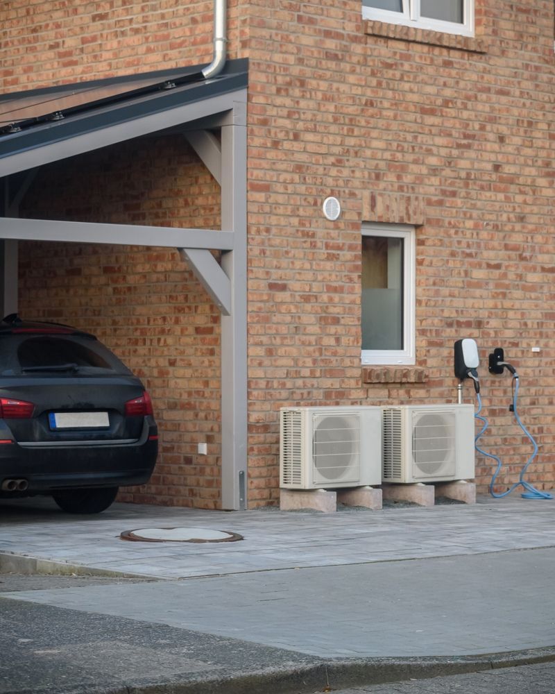 A Building With Ac Units and an EV Charger on the Wall — Abode Electrical in Carrington, NSW