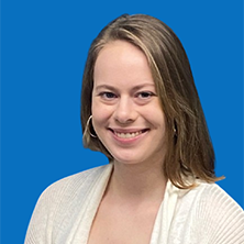 Woman with fair skin, smiling, hoop earrings, light brown hair, against a blue backdrop.