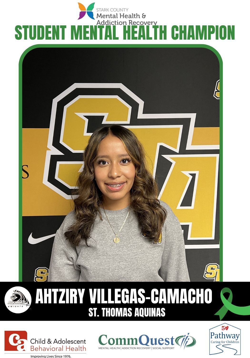 Ahtziry Villegas-Camacho, student mental health champion, smiles in front of a school banner.