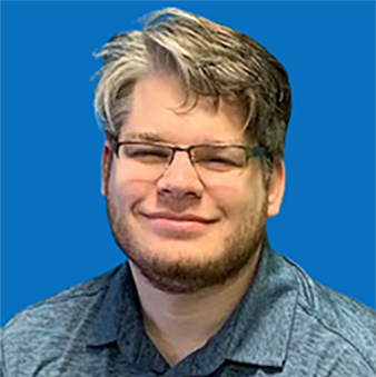 Man with glasses smiling, gray and brown hair, blue polo, against a blue background.
