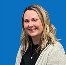Woman with blonde hair, smiling, wearing a nose ring, against a blue backdrop.