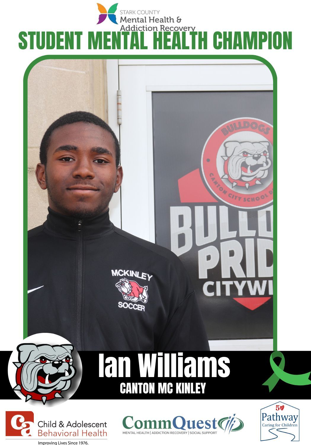 Ian Williams, Student Mental Health Champion. Young Black man in front of a school door, wearing soccer gear.