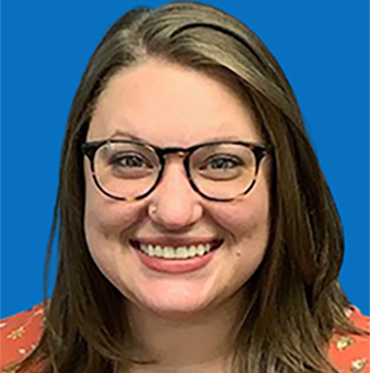 Woman with glasses smiles at camera, blue background.