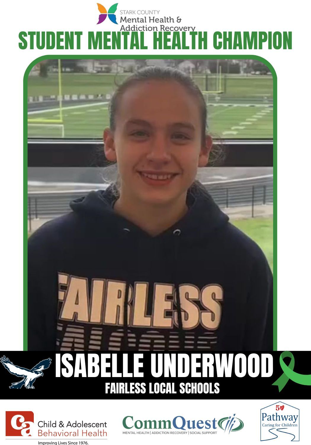 Isabelle Underwood, Student Mental Health Champion, in front of a sports field, wearing a Fairless sweatshirt.