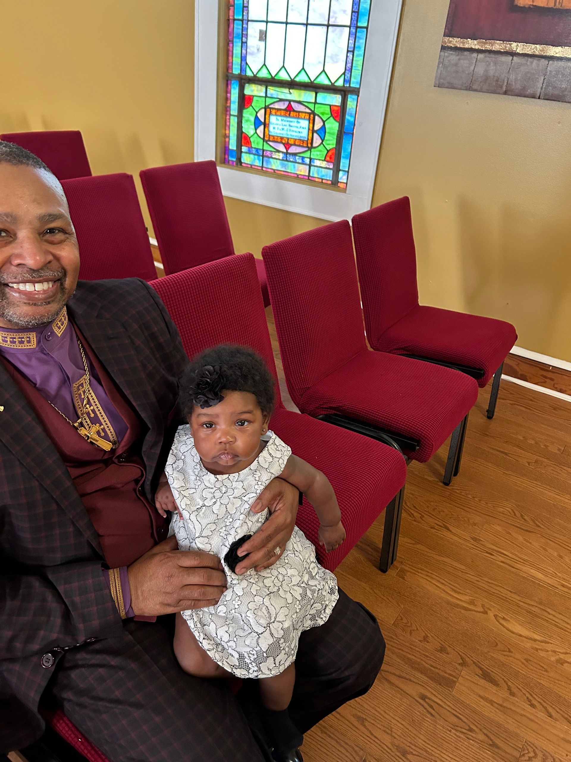 Man in a blue suit and woman in black suit having a discussion indoors.