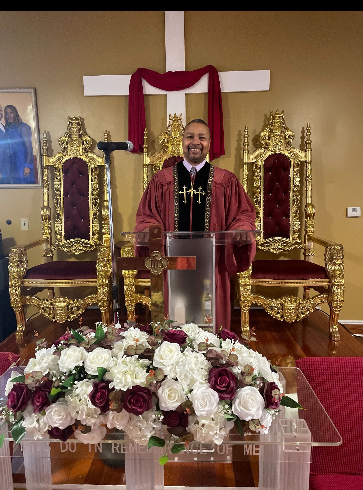 People seated in pews inside a church, lit by sunlight streaming through arched windows.