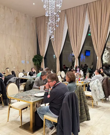 Un gruppo di persone è seduto ai tavoli di un ristorante.