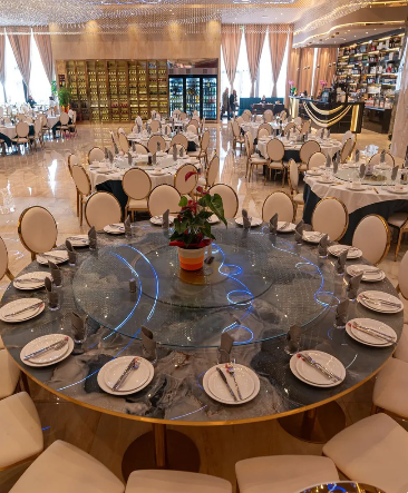 Una grande sala con tavoli e sedie allestita per un banchetto