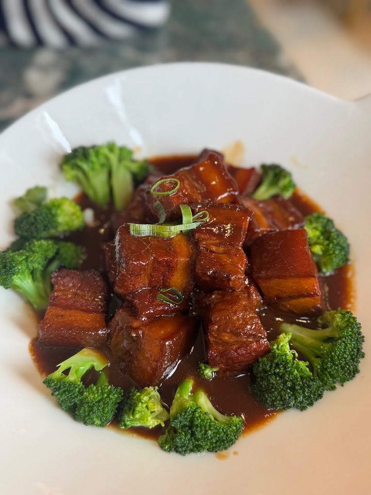 Un primo piano di un piatto di cibo con broccoli e carne su un tavolo.