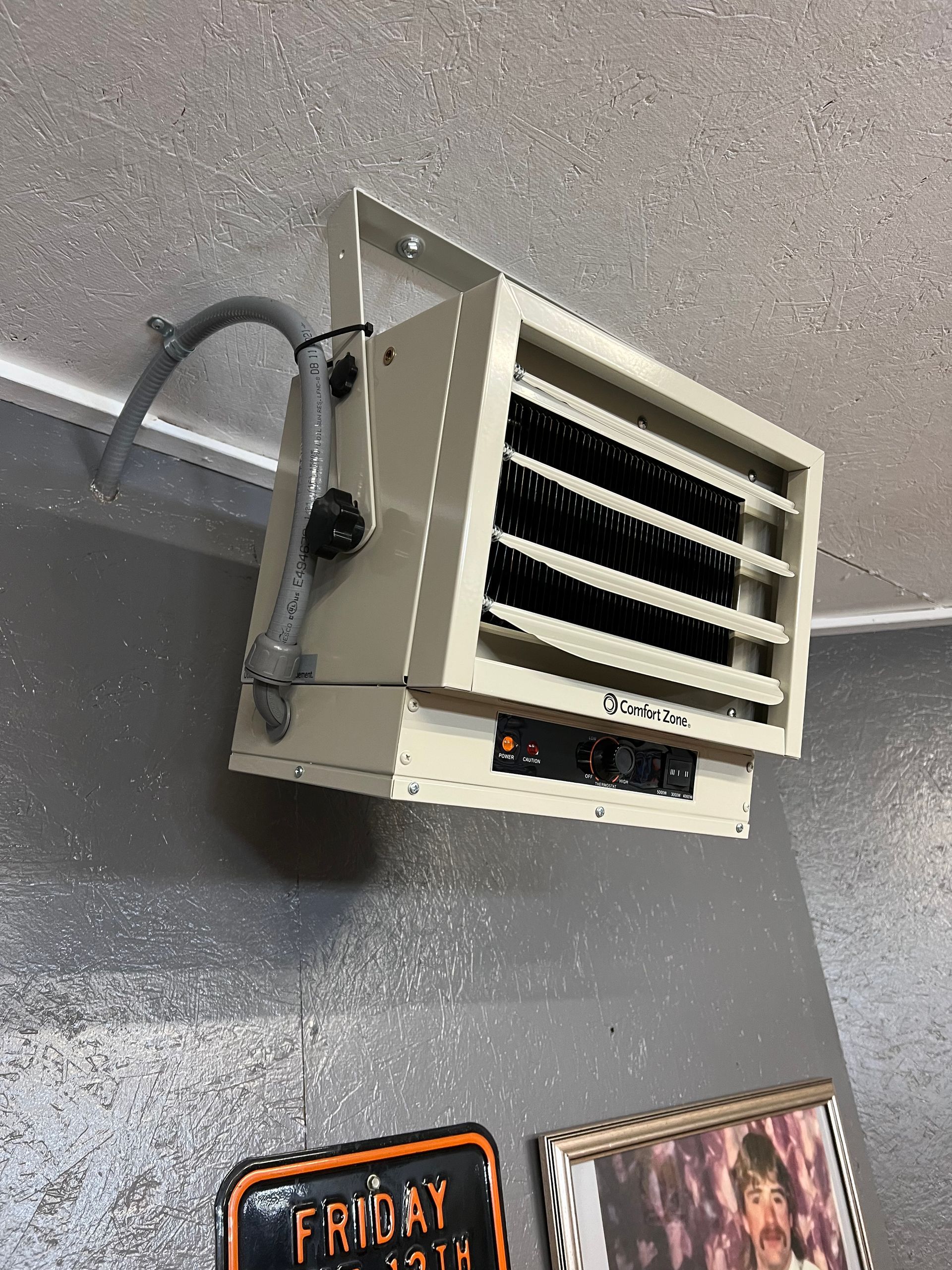 A heater is hanging from the ceiling in a room.