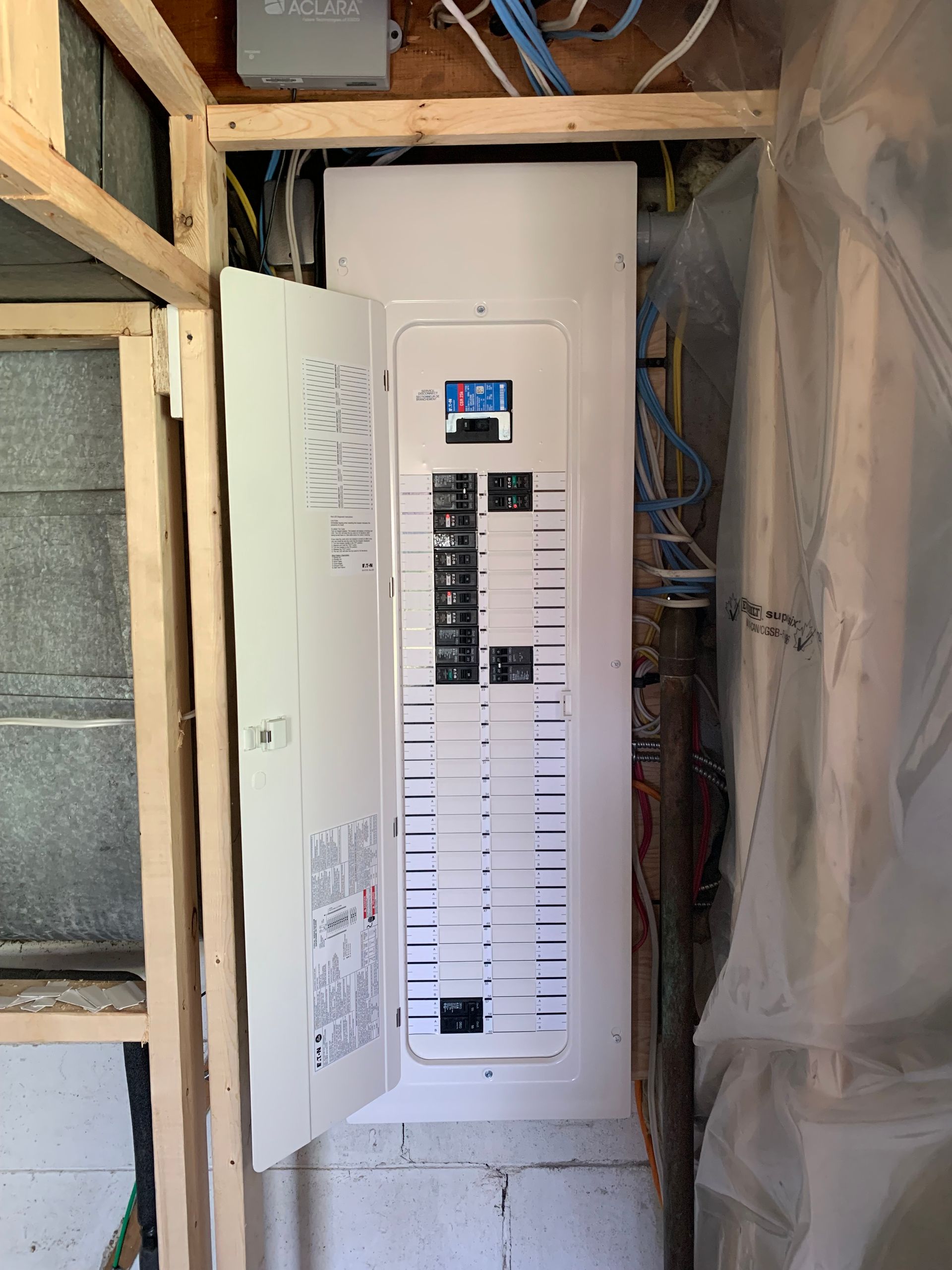 A white electrical box is sitting in a corner of a room.
