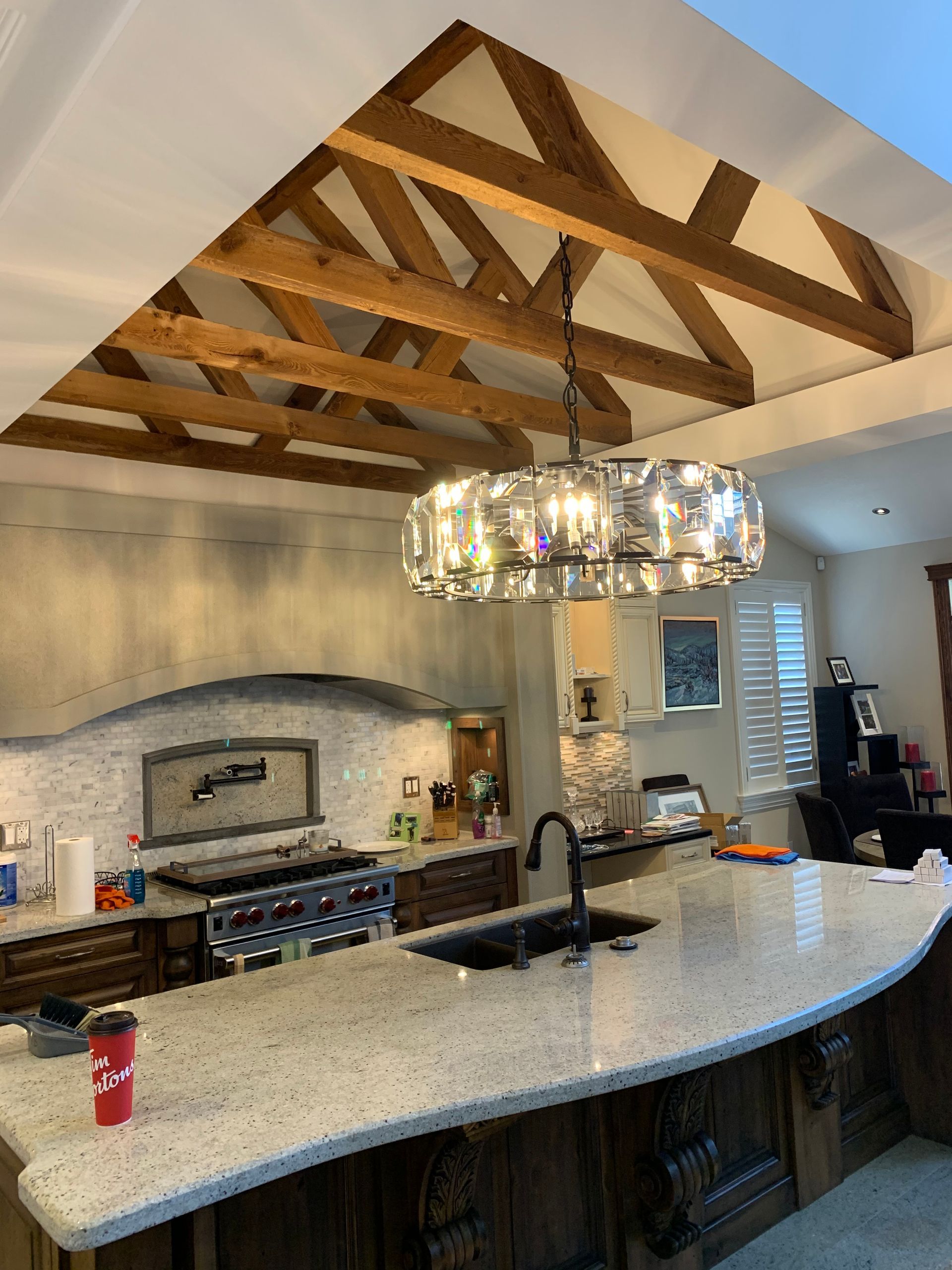 A kitchen with a large island and a chandelier hanging from the ceiling.