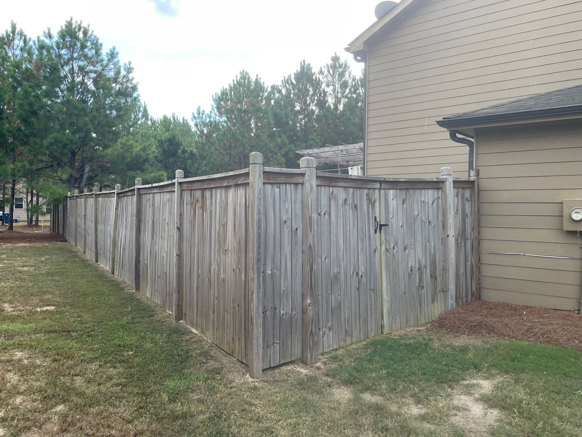 A wooden fence is in front of a house