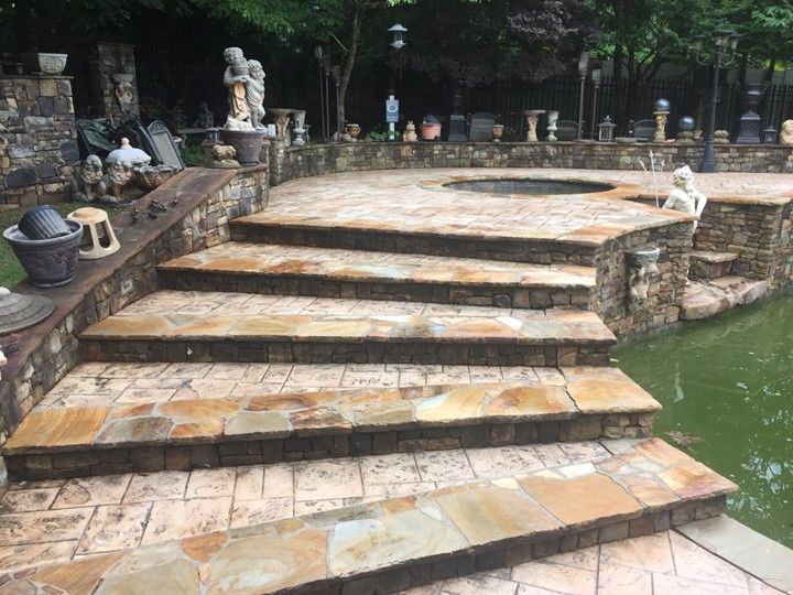 A set of stairs leading up to a pool next to a pond.