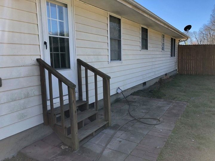 A white house with stairs leading up to the front door