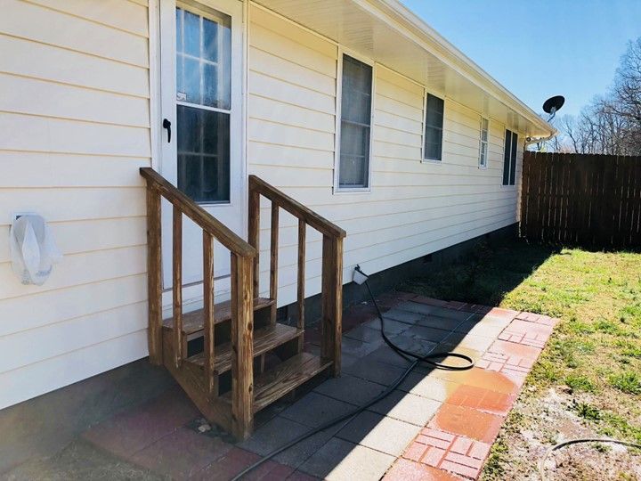 A white house with a wooden deck and stairs