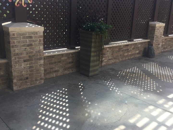 A brick wall with a planter in front of it.