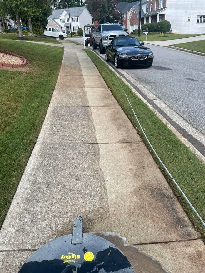 A black car is parked on the side of the road next to a sidewalk.