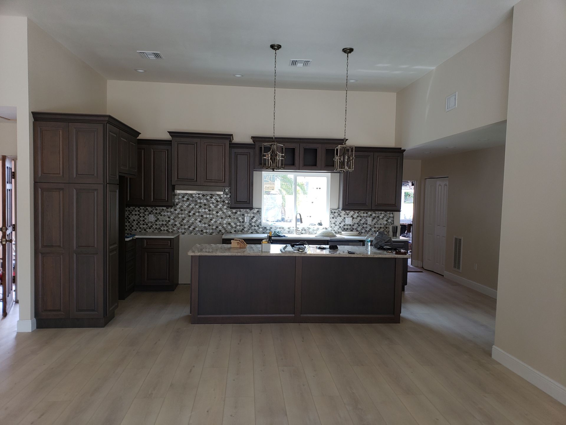 a kitchen with white cabinets , wooden counter tops , stainless steel appliances and a large island .