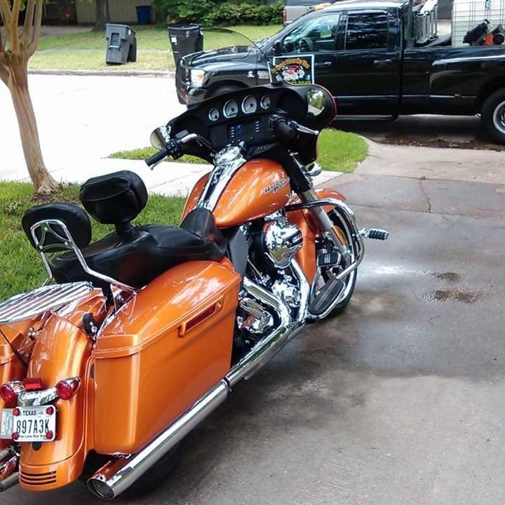 An orange harley davidson motorcycle with a texas license plate