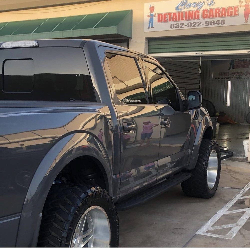 A truck is parked in front of a detailing garage
