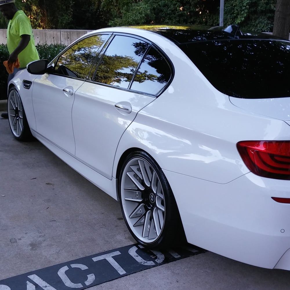A white car is parked next to a sign that says act