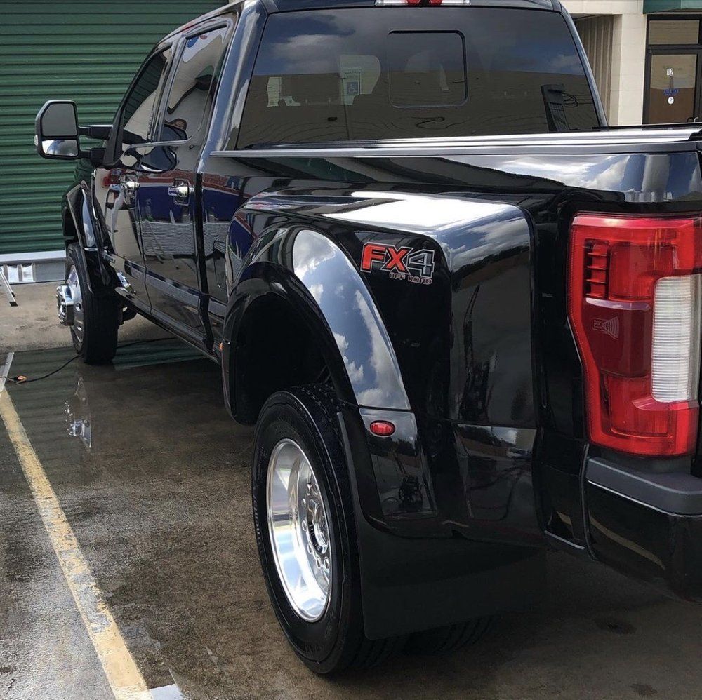 A black ford truck is parked in a parking lot