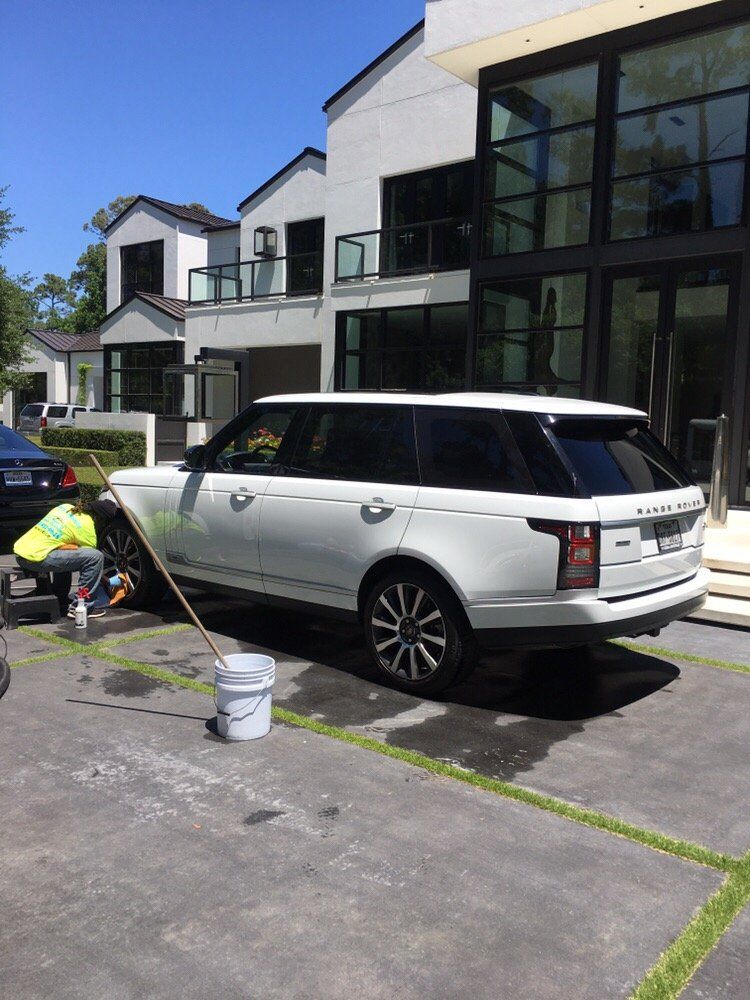 A white range rover is parked in front of a house