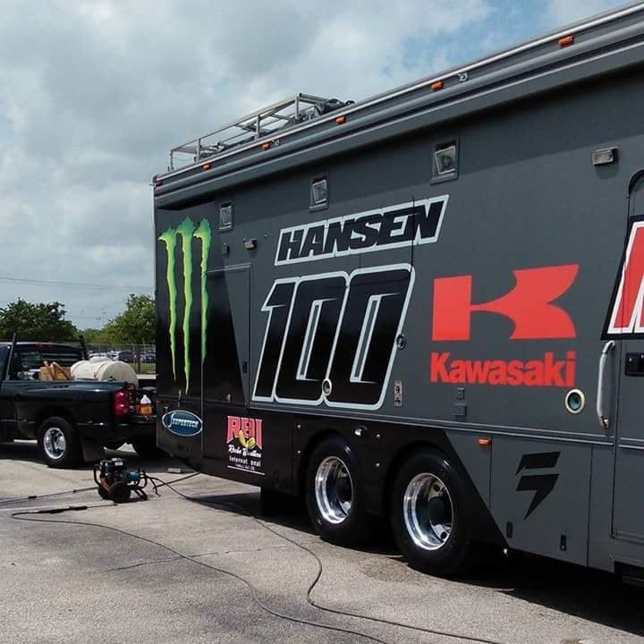 A hansen 100 kawasaki trailer is parked next to a truck