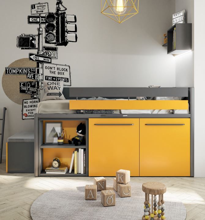 Un letto a soppalco salvaspazio con scrivania e mensole nei toni del grigio e del giallo acceso, inserito in una stanza con un adesivo murale raffigurante un segnale stradale