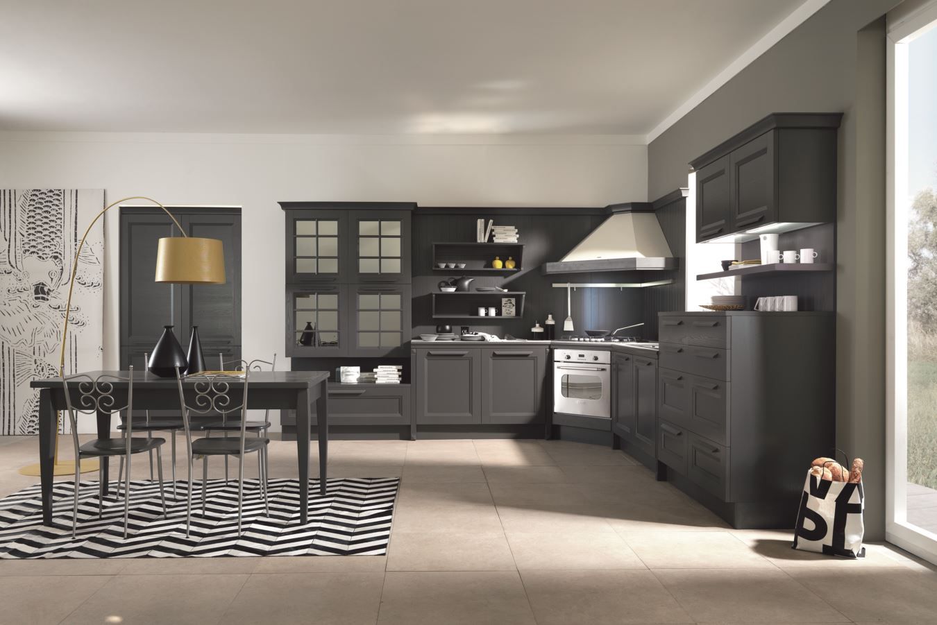 Cucina grigio scuro Aran con zona pranzo; mobili, fornello, tavolo, sedie e tappeto a fantasia.