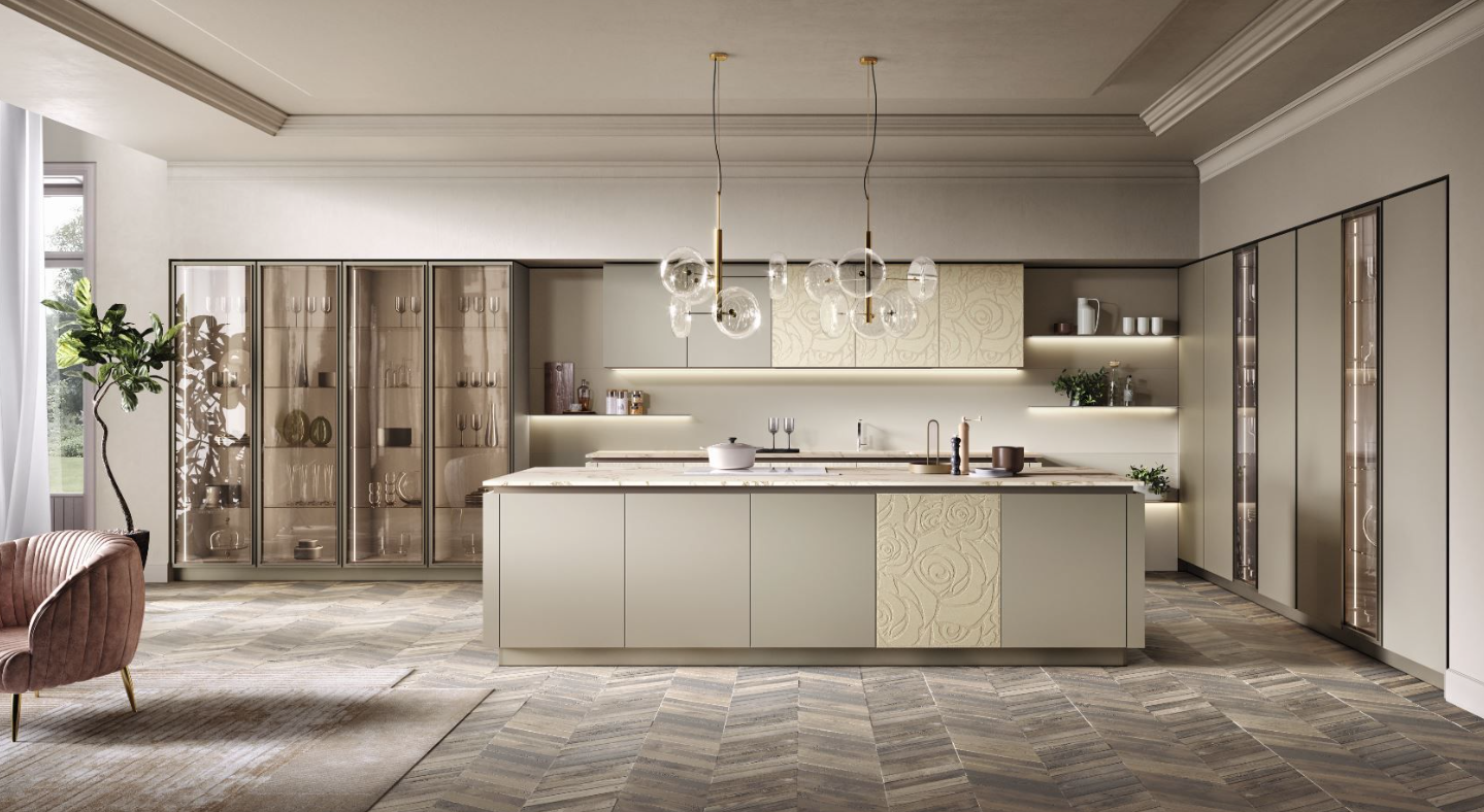 Cucina moderna con isola, colori neutri, dettagli dorati, mobili in vetro e luci sospese.