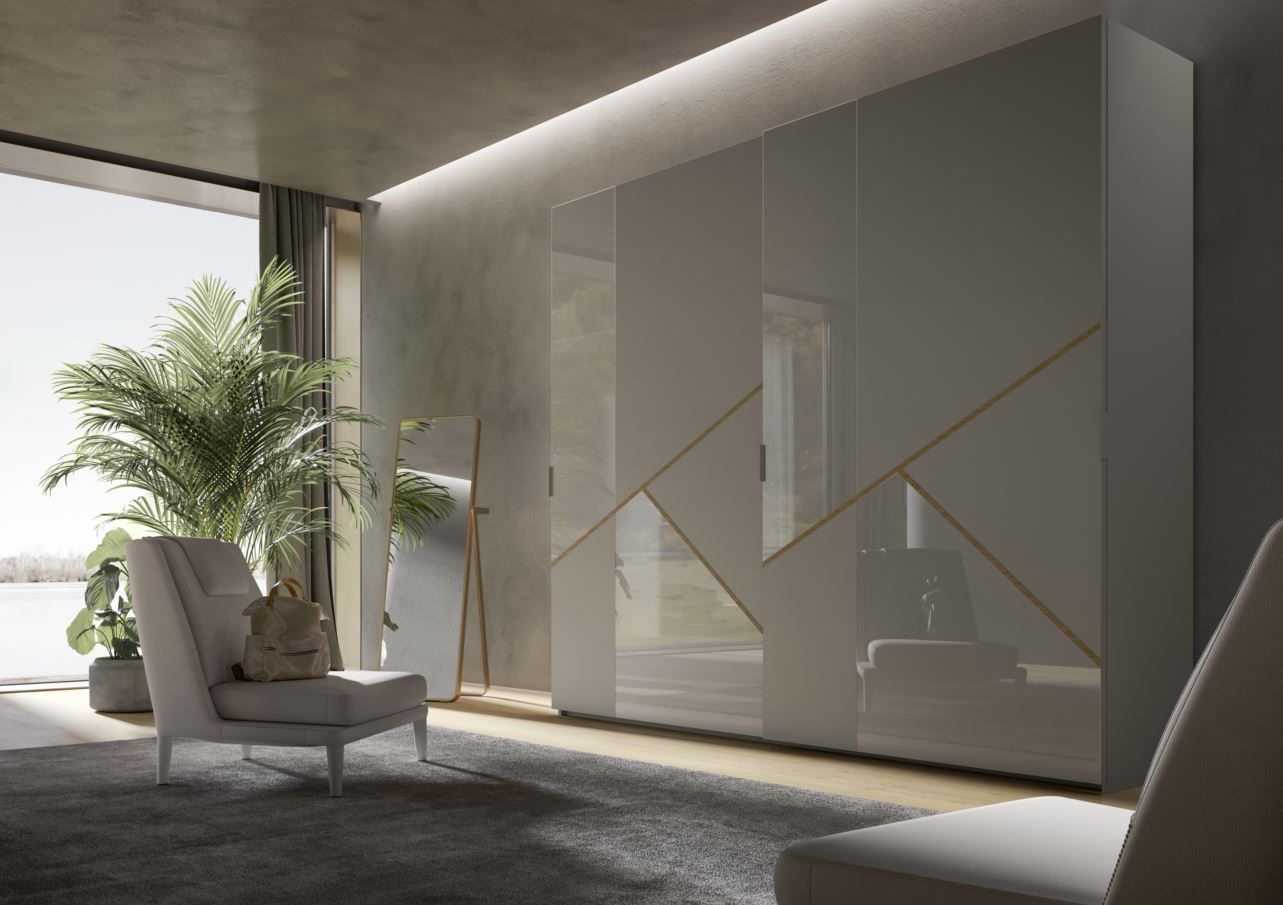 Camera da letto moderna con un grande armadio grigio, finiture dorate e una sedia bianca.