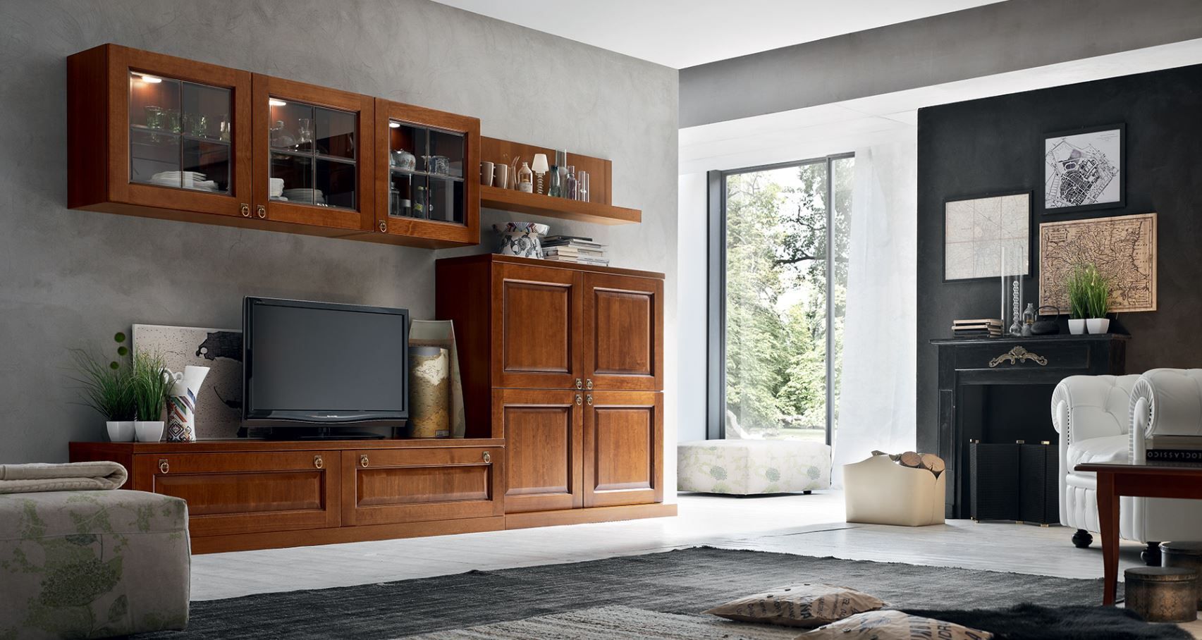 Mobiletto in legno con TV, mobili con ante in vetro e spazio per riporre gli oggetti contro una parete grigia, vicino a una finestra.