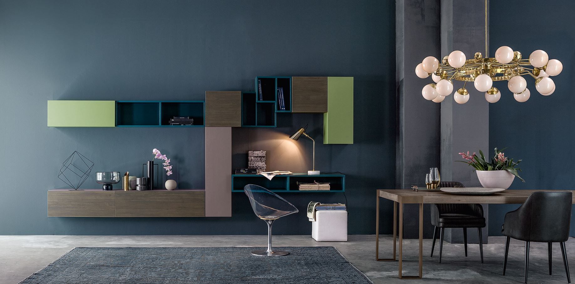 Soggiorno moderno con pareti blu, scrivania, tavolo da pranzo e lampadario a forma di globo.