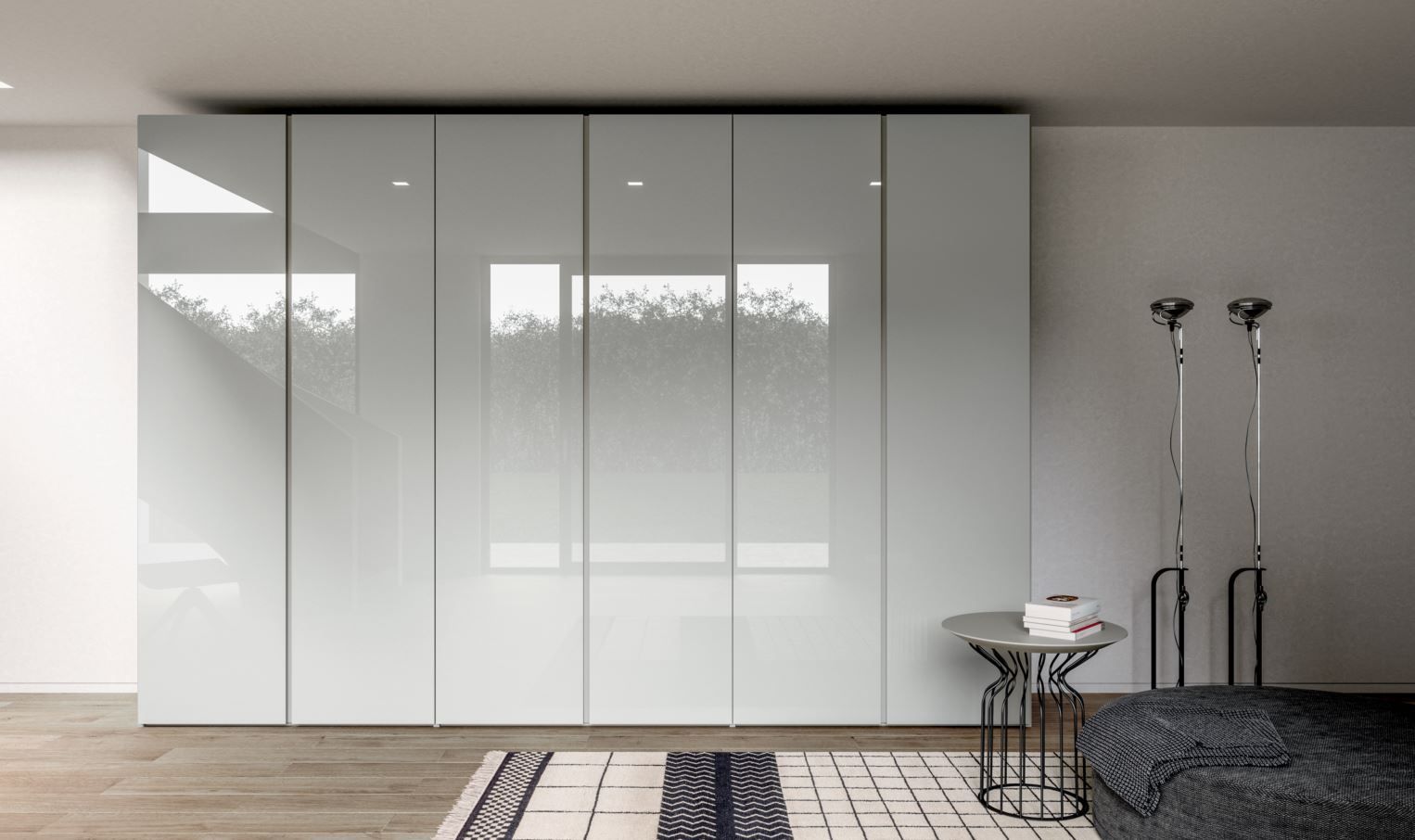 Un grande armadio bianco lucido contro una parete bianca. Di fronte, un tappeto e un tavolino.