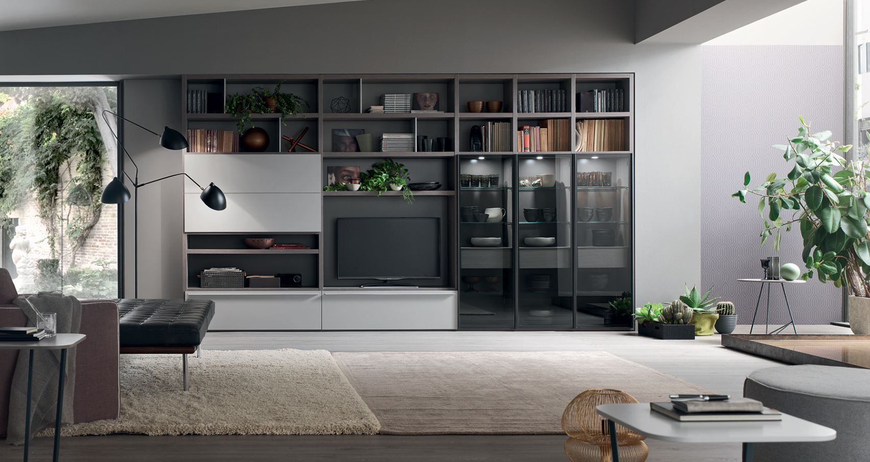 Soggiorno moderno con un grande centro multimediale, librerie e un divano scuro.