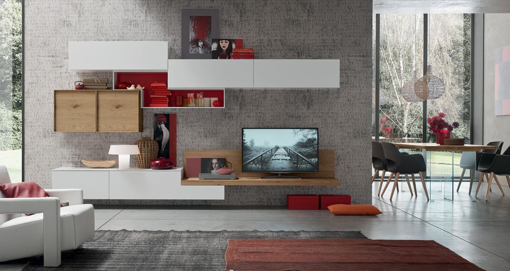 Soggiorno moderno con mobili contenitori bianchi e rossi a parete, TV e zona pranzo visibile attraverso una finestra.