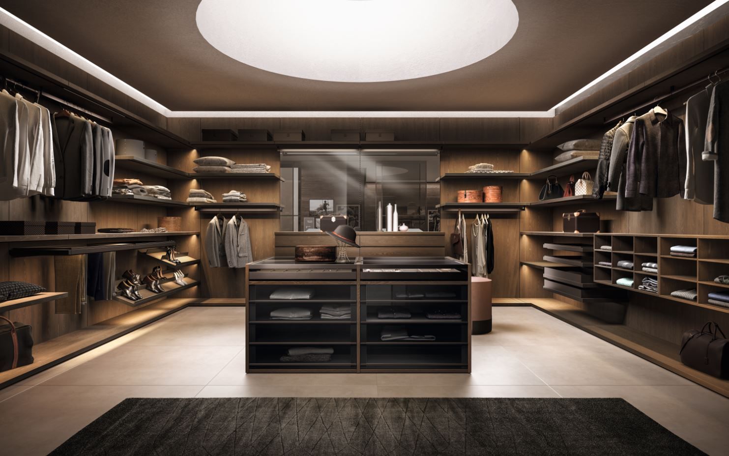 Una lussuosa cabina armadio con ripiani in legno scuro, vestiti, scarpe e un'isola al centro, illuminata da una grande lampada circolare.