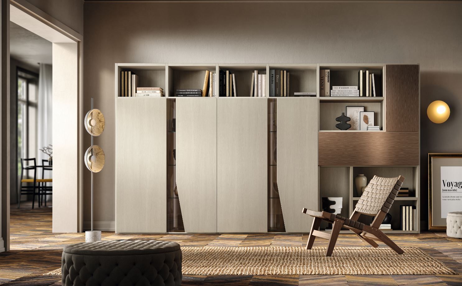 Soggiorno con mobili a muro, libri, sedia e tappeto. Dominano i toni della terra.